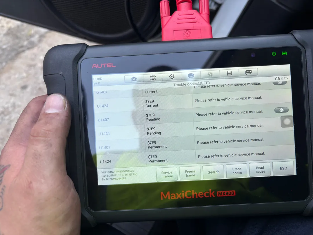 Scan tablet screen showing catalyst efficiency and communication fault codes with pending and permanent status flags
