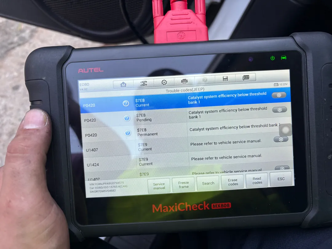Professional Autel MaxiCheck tablet held in one hand listing multiple stored and pending trouble codes