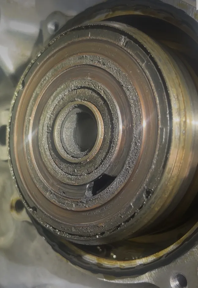 Macro view of a camshaft actuator bore in a cylinder head showing bearing surfaces and oil varnish