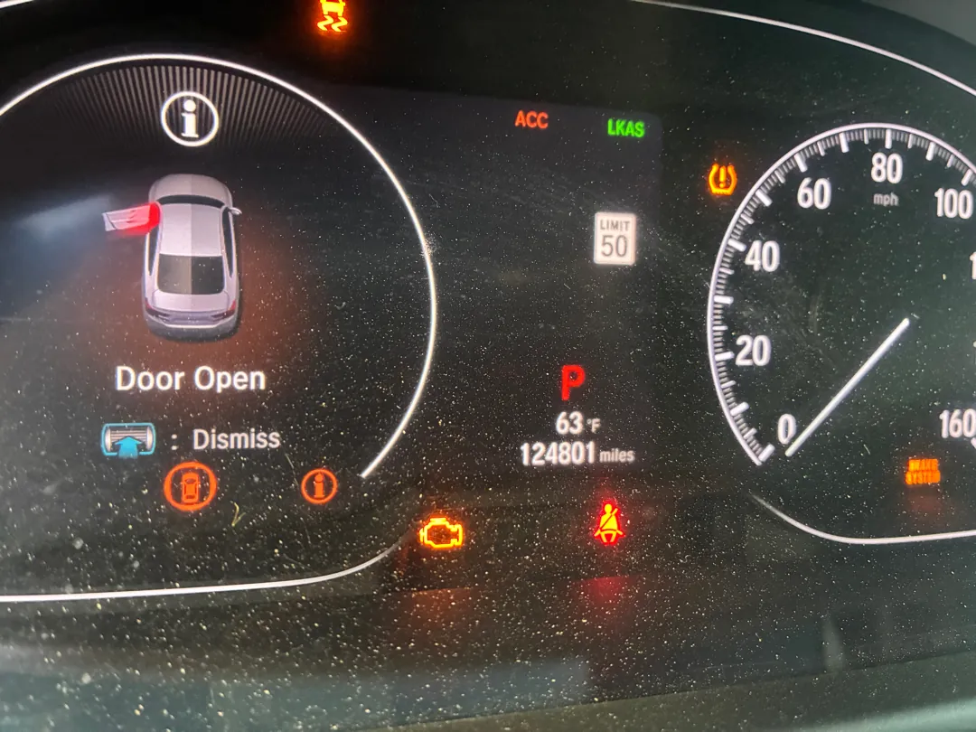 Instrument cluster lit with multiple warning lamps including check engine, tire pressure and brake system