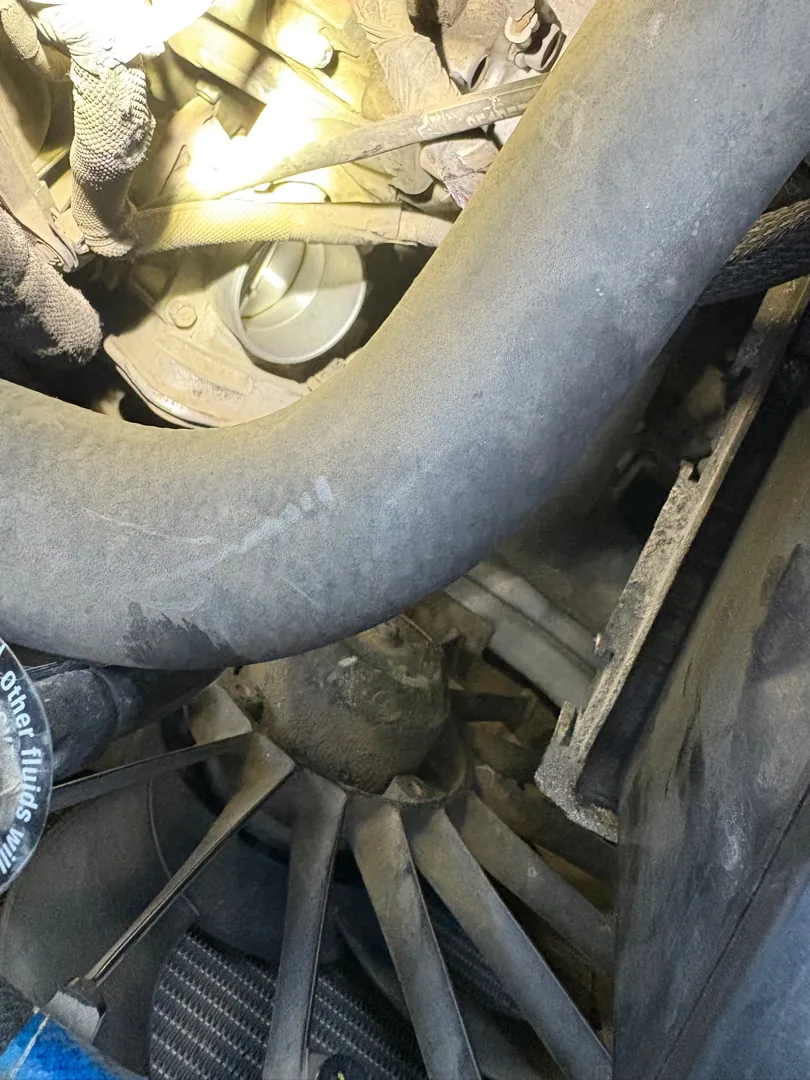 Underbody view of an exhaust pipe, heat shield and suspension components on a raised vehicle