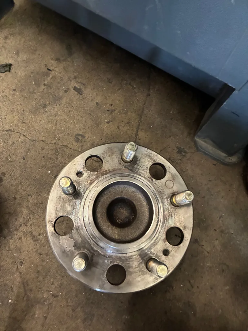 Wheel hub and bearing flange removed from a vehicle and photographed on the shop floor